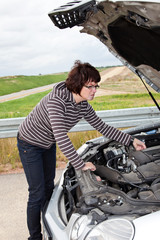 Frau vor geoeffneter Motorhaube 647