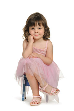 Pretty the little girl sits on a stool