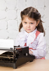 little girl prints on the ancient typewriter.