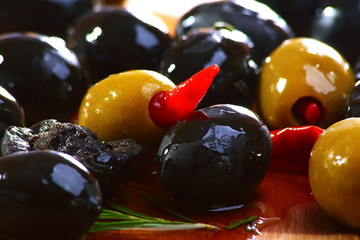 Black and green olives on a wooden table.