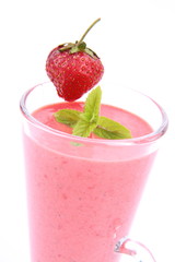 Strawberry shake in a glass decorated with a strawberry and mint