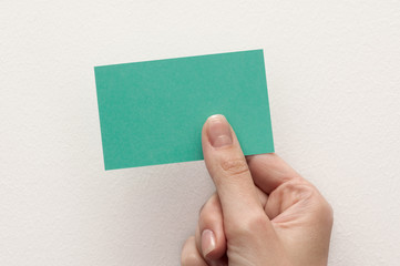 business card in hand on white background