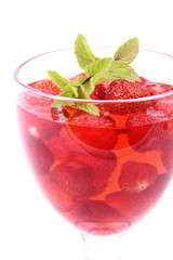 Jelly with strawberries decorated with a mint twig in a cup