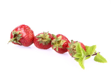 Strawberries with a mint twig on white background