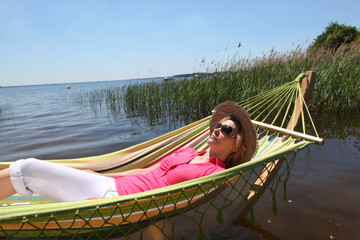 Obraz premium Woman in hammock by lake