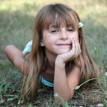 Fillette allong&eacute;e dans l'herbe (&eacute;t&eacute; 6 ans)