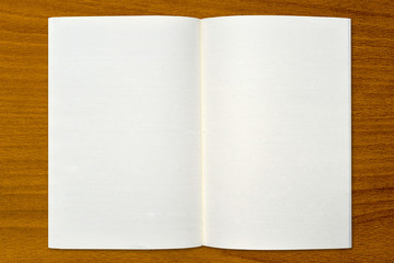 White open notebook on wood background.