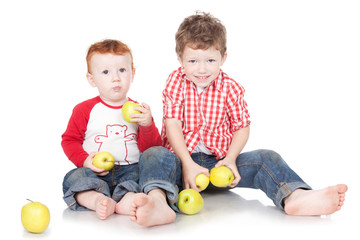 Two brothers eating green apples