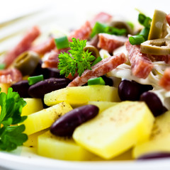 Potato salad with salami, bean and olives