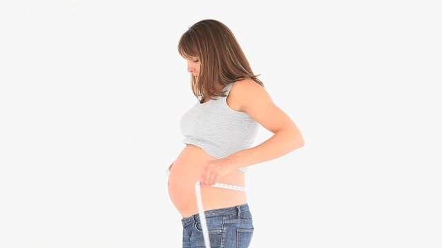 Pregnant woman measuring her tummy