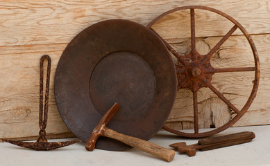 Old mining tools, gold pan, picks against wood background