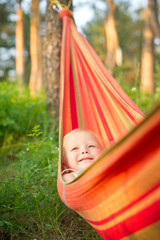 Adorable baby rest in hammock under trees