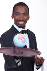 Restaurant waiter carrying small globe on tray