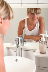 Young woman standing at a bathroom sink