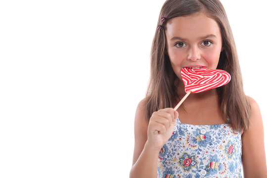 Young Girl Eating A Heart Shaped Lollypop