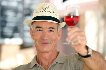 old man raising a glass of claret