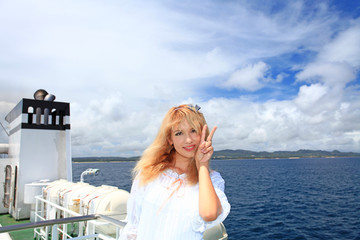 Fototapeta na wymiar フェリーに乗り伊平屋島へ向かう笑顔の女性