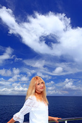 Fototapeta na wymiar 青い空に浮かぶ大きな雲と笑顔の女性