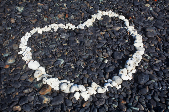 Fototapeta Heart made with white stone on black stone