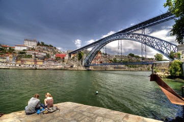 Tourists relaxing by Dom Luís Bridge, Porto, Portugal.