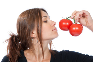 Young woman smell red tomatoes