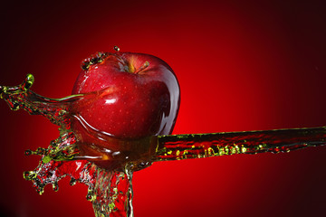 Panele Szklane  czerwone jabłko w strumieniu soku