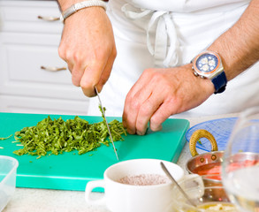Chef cutting the parsley on a board