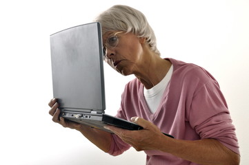 Seniorin hat Schwierigkeiten den Laptop zu lesen