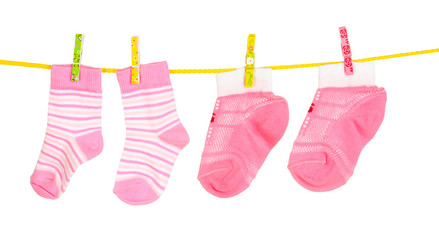 pink baby socks on rope isolated on white