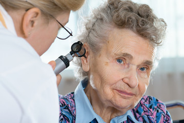 Doctor performing ear exam with otoscope