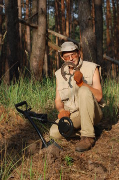 Man with metal detector and Soviet WWII F-1 hand-grenade
