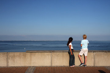Mädchen und Junge blicken auf das Meer