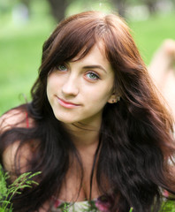 portrait of beautiful young woman relaxing in summer park