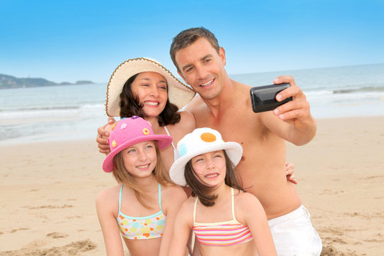 Family taking picture of themselves at the beach