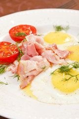 fried eggs with bacon and vegetables