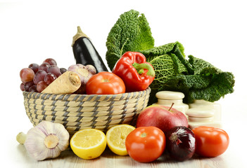 Raw vegetables and wicker basket isolated on white