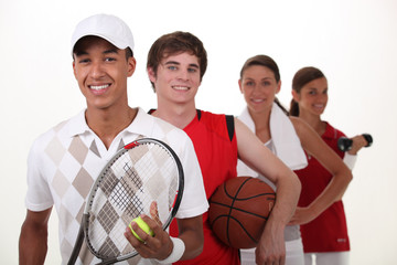 Four teenagers dressed for different sports