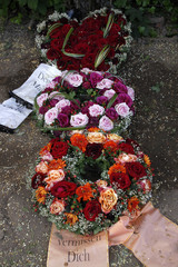 Naklejka premium Blumen und Kränze auf einem frischen Grab