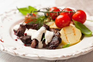 Rustic beef dish with grilled potatoes and sauce