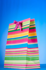 Colourful paper shopping bags against gradient background