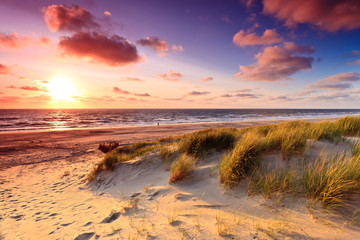 Bord de mer avec dunes de sable au coucher du soleil