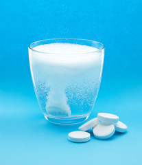 Effervescent tablet in glass of water with bubbles