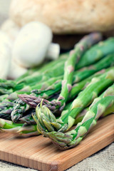 Fresh green asparagus on cutting board, closeup shot