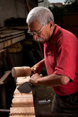 woodcarver working with mallet and chisel