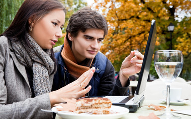 Couple sitting laptop park