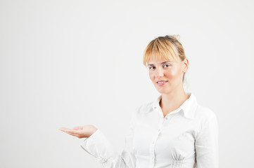 Happy smiling young business woman showing blank area for sign o