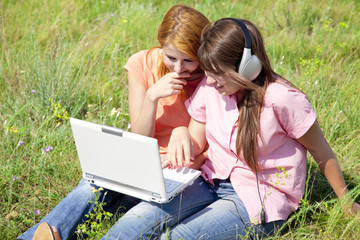 Two girlfriends at countryside with laptop and computer.