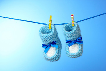 baby booties from a rope on a blue background