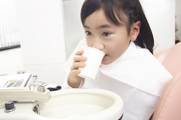 歯科治療後にうがいをする子供