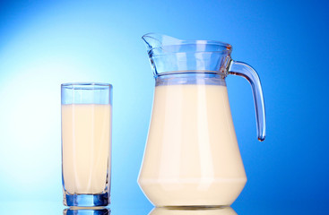 Pitcher and Glass with milk on blue background